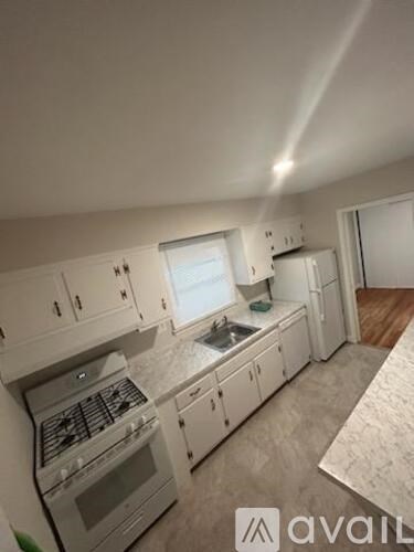 A kitchen with white cabinets and a stove top oven.