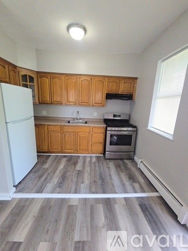 A kitchen with wooden cabinets and a white fridge.