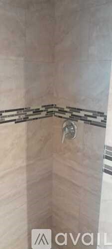 A shower with a silver faucet and a black and white striped shower curtain.