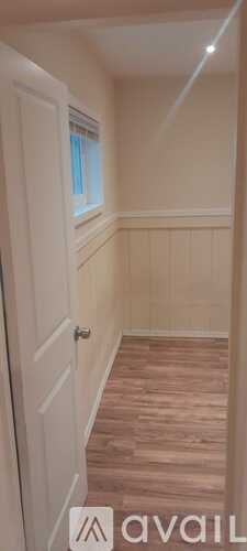 A room with wooden flooring and white walls.