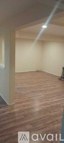A room with wooden flooring and white walls.
