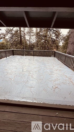A wooden deck with a pool covered in ice.
