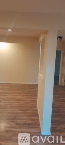 A room with wooden flooring and white walls.