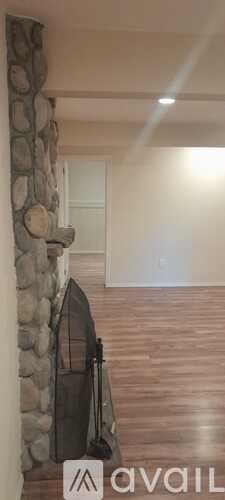 A stone fireplace with a fireplace screen and a bag on the floor.