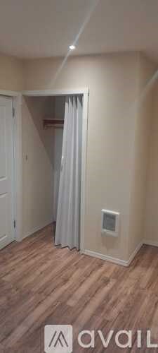 A room with wooden flooring and a white door.