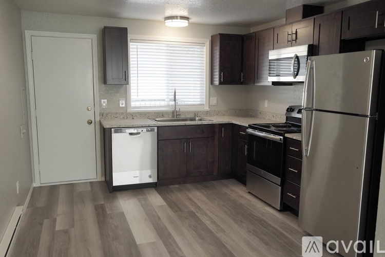 A kitchen with a refrigerator, sink, and stove.