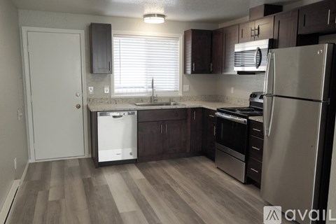 A kitchen with a refrigerator, sink, and stove.