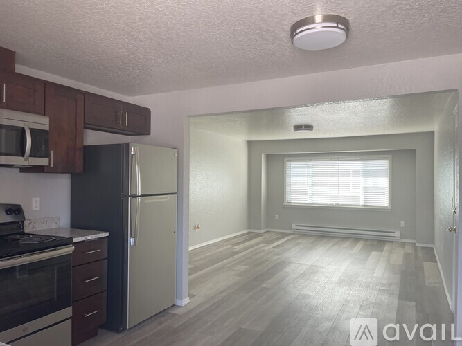 A kitchen with a refrigerator, microwave, and oven.
