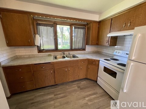 A kitchen with wooden cabinets and a white refrigerator.