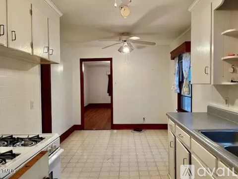 A kitchen with white cabinets and a white stove.