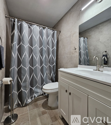 A bathroom with a white toilet, a sink, and a shower curtain.