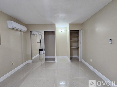 A spacious room with a tiled floor and a walk-in closet.