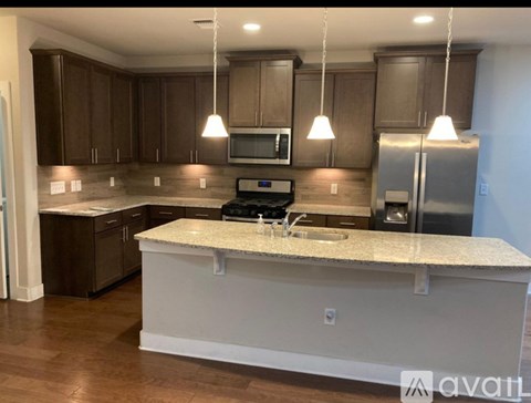 A kitchen with brown cabinets and a white island.