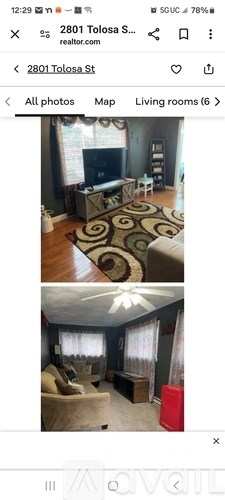A living room with a television and a rug.