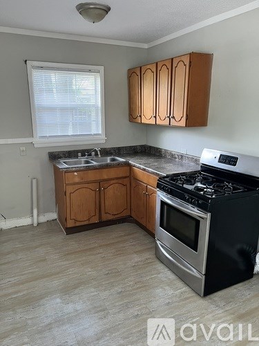A kitchen with wooden cabinets and a black stove top oven.