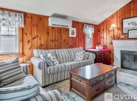 A living room with a striped couch and a wooden coffee table.