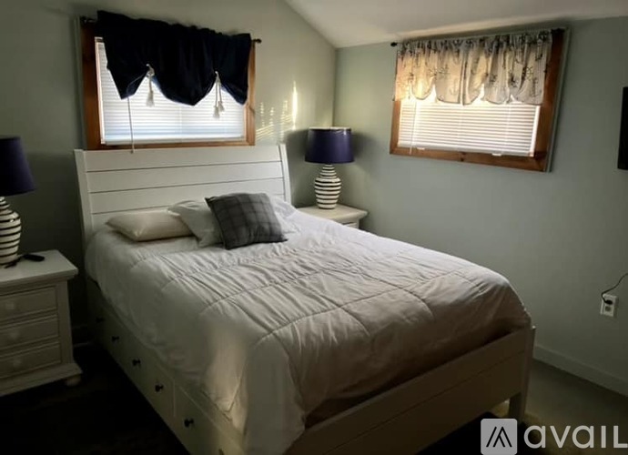 A bedroom with a bed, nightstands, and two lamps.