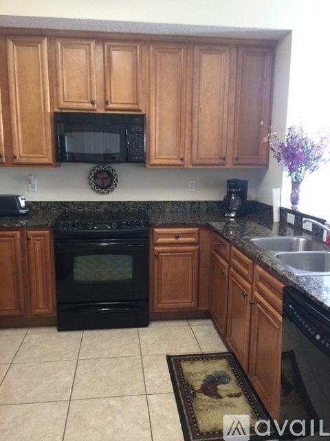A kitchen with wooden cabinets and black appliances.