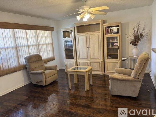 A living room with a recliner, a chair, and a cabinet.