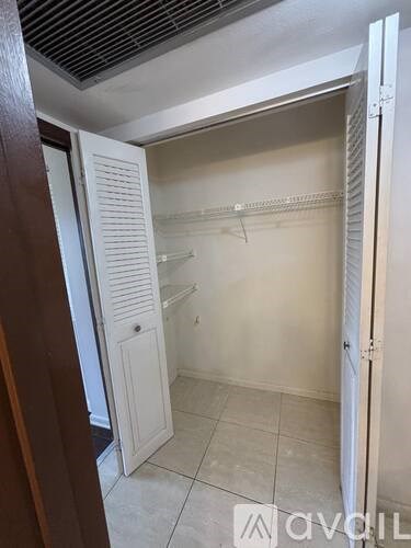 A white pantry with a door open.