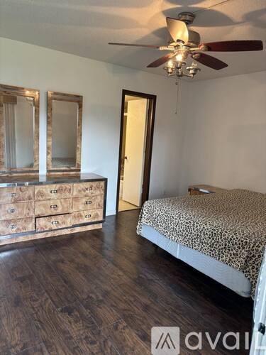 A bedroom with a bed, dresser, and mirror.