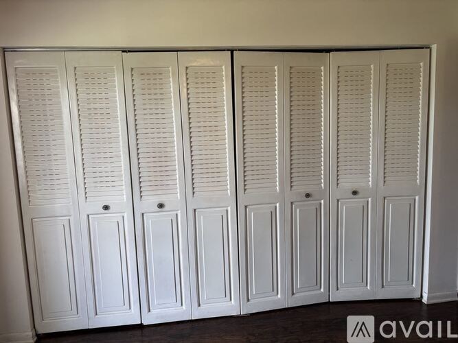 A set of white wooden wardrobes with sliding doors.