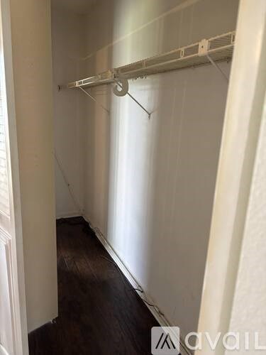 A long hallway with a white wall and a white rail on top.