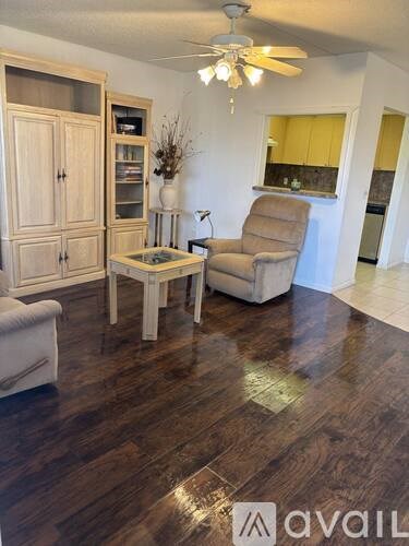 A living room with a brown chair and a wooden floor.