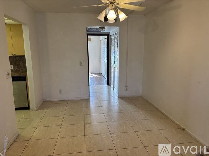 A spacious room with a ceiling fan and tiled floor.