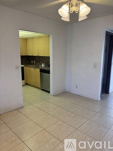 A kitchen with yellow cabinets and a tiled floor.