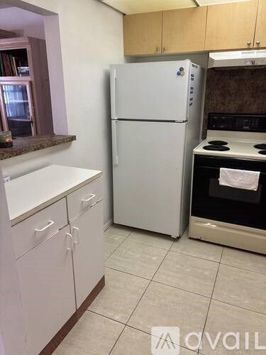 A kitchen with a white fridge and a black stove.