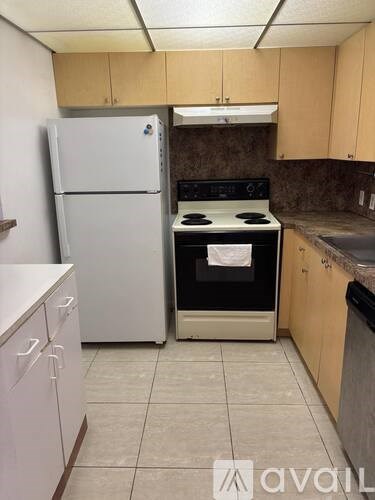 A kitchen with a white fridge and a black stove top oven.
