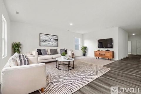 A living room with a white couch, a coffee table, and a painting on the wall.
