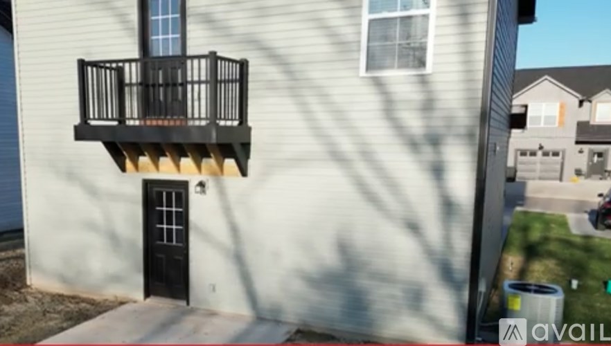 A balcony with a black railing is on the second floor of a house.