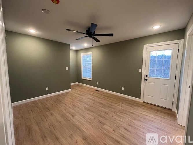 A room with a ceiling fan and a door leading to a balcony.