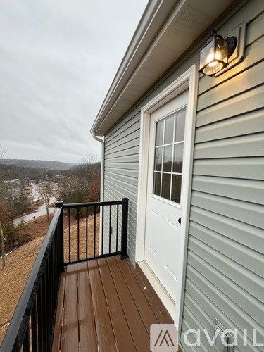 A balcony with a white door and a black railing.