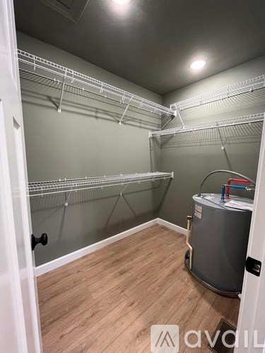 A small, empty room with a wall-mounted refrigerator and a door on the left.