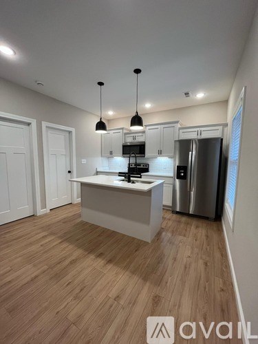 A kitchen with wooden floors and white walls.