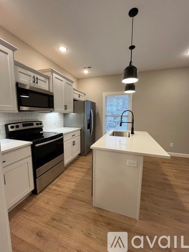 A kitchen with white cabinets and a wooden island.
