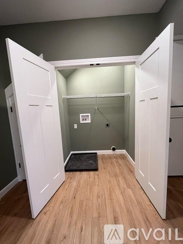 A room with a white door and wooden floor.