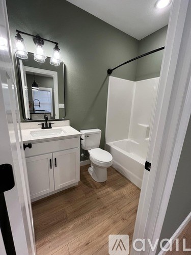 A bathroom with a white toilet, sink, and bathtub.