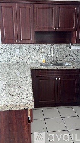 A kitchen with brown cabinets and a granite countertop.