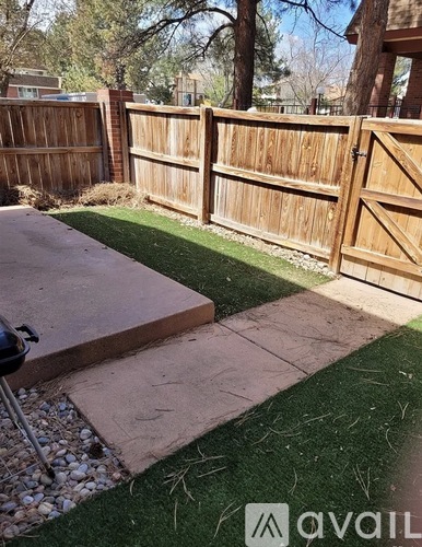 A backyard with a wooden fence and a concrete patio.