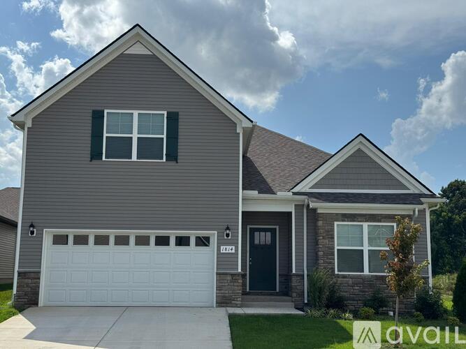 A two-story house with a garage and a driveway.