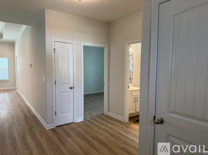 A room with a white door and a white cabinet with a sink.