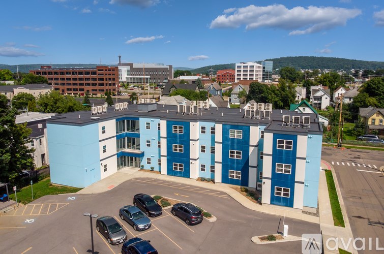 A parking lot with cars and a blue and white building in the background.