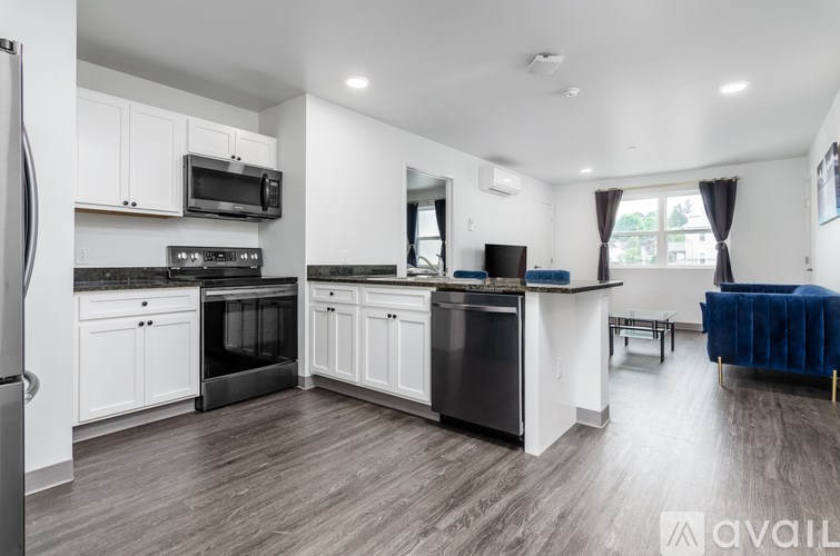 A modern kitchen with white cabinets and black appliances.