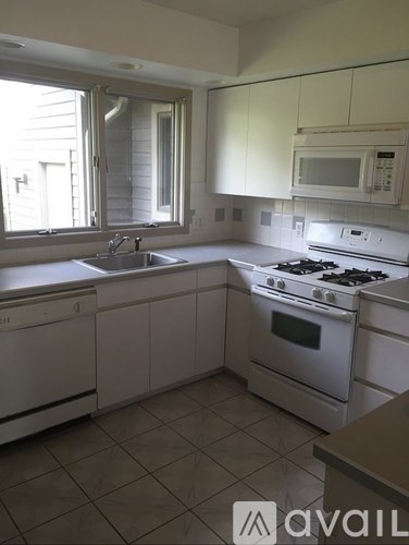 A kitchen with white appliances and cabinets.