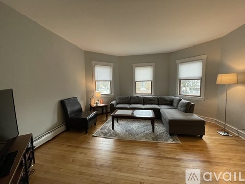 A living room with a grey couch and a black chair.