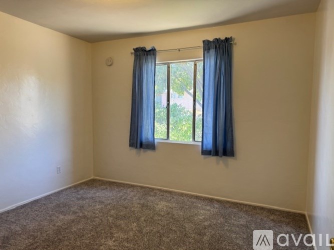 A room with a window covered by blue curtains.